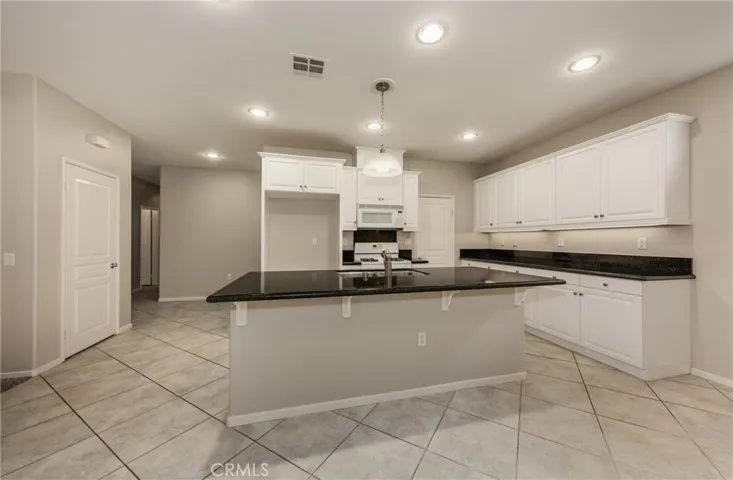 Kitchen with Island, Walk in PantryDinning Area with Ceiling Fan and Tile Flooring