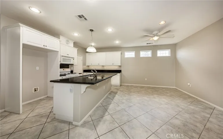 Kitchen with Island, Walk in PantryDinning Area with Ceiling Fan and Tile Flooring