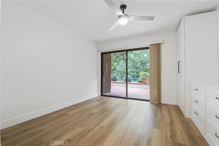Downstairs bedroom that opens to the tranquil backyard patio with peaceful tree view.