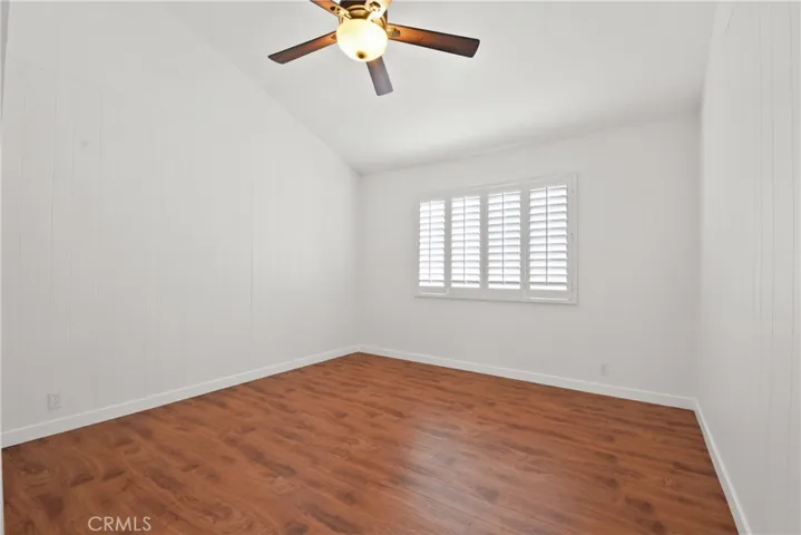 Front upstairs bedroom with decorative ceiling fan, and plantation shutters and recently installed laminate flooring