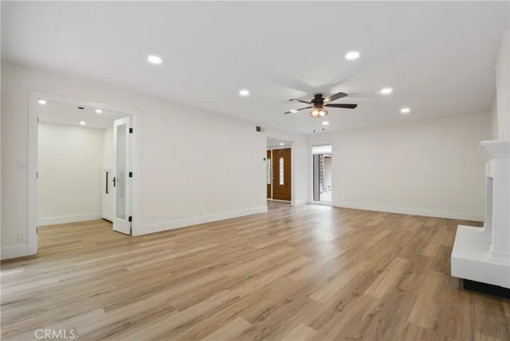 Spacious living room with recently remodeled fireplace, newer laminate flooring and new verticle blinds.