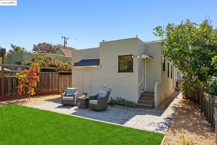 Back of house with a fenced backyard, a patio area, and stucco siding