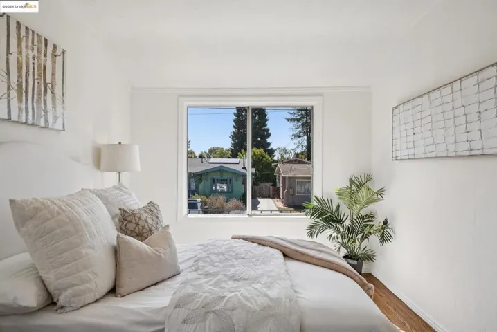 Bedroom with wood finished floors and ornamental molding