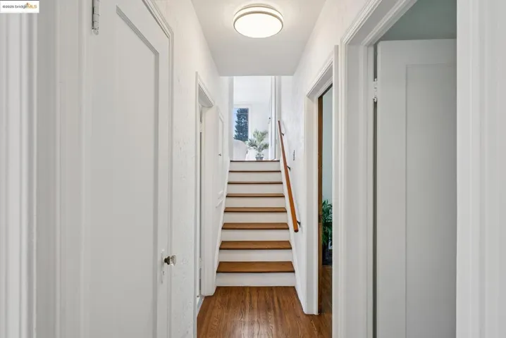 Stairway featuring wood finished floors