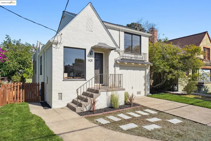 View of front of house featuring a balcony, stucco siding, and a chimney