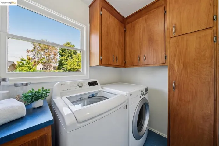 Washroom with cabinet space and washing machine and dryer