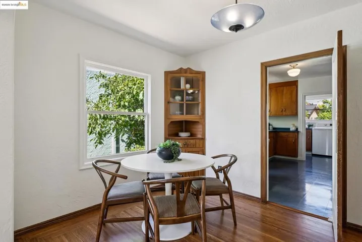 Dining area with a textured wall, dark wood finished floors, and washer / dryer