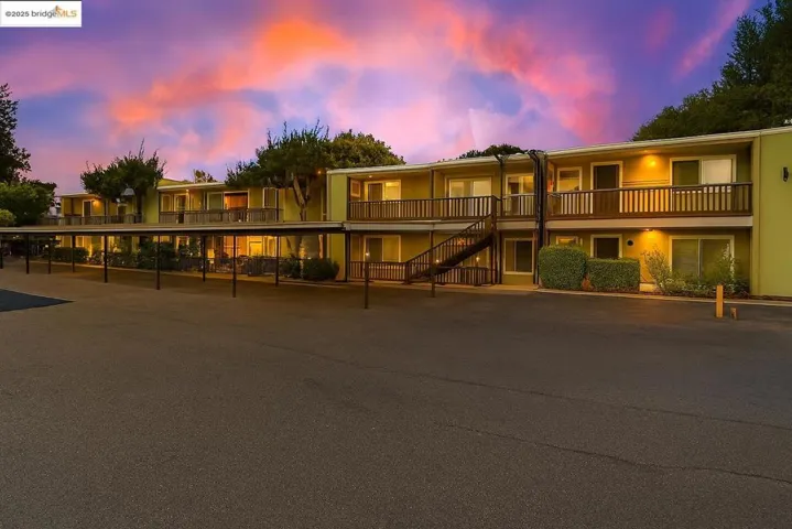 View of front of property featuring stairway and covered parking