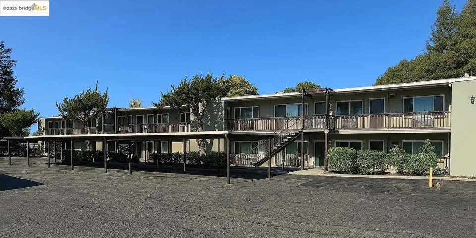 View of property featuring stairs and covered parking