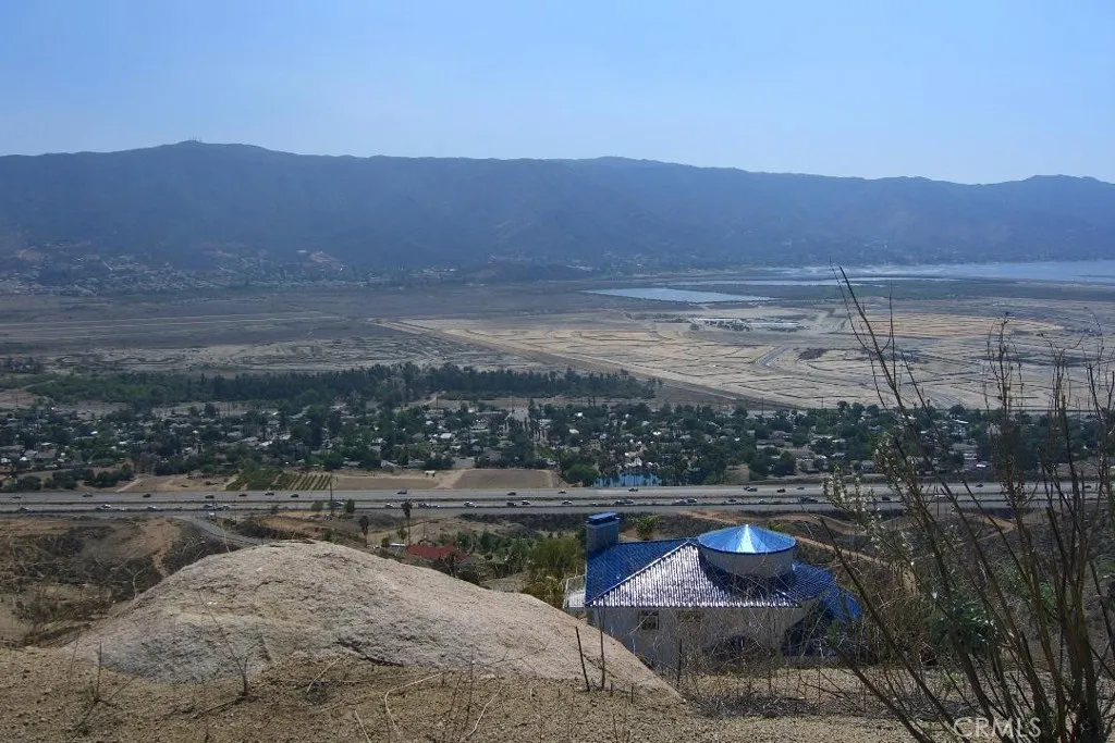 A blue roof custom home on the lot below this property's building pad. There are a few homes dotting the landscape in the area. This picture depicts one of the magnificent views.