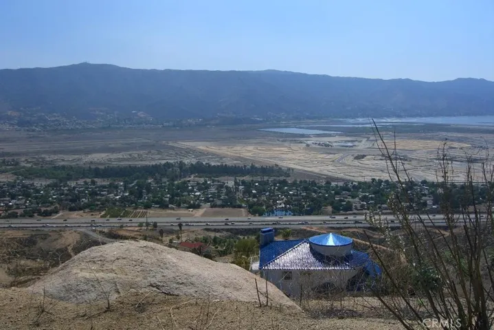 A blue roof custom home on the lot below this property's building pad. There are a few homes dotting the landscape in the area. This picture depicts one of the magnificent views.