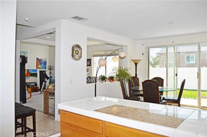 Light and Bright Kitchen with An Added Breakfast Bar with a Granite Insert for Dough-Making, Tile Floors, & a Pantry