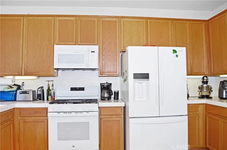 Light and Bright Kitchen with An Added Breakfast Bar with a Granite Insert for Dough-Making, Tile Floors, & a Pantry