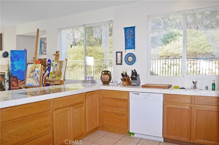 Light and Bright Kitchen with An Added Breakfast Bar with a Granite Insert for Dough-Making, Tile Floors, & a Pantry