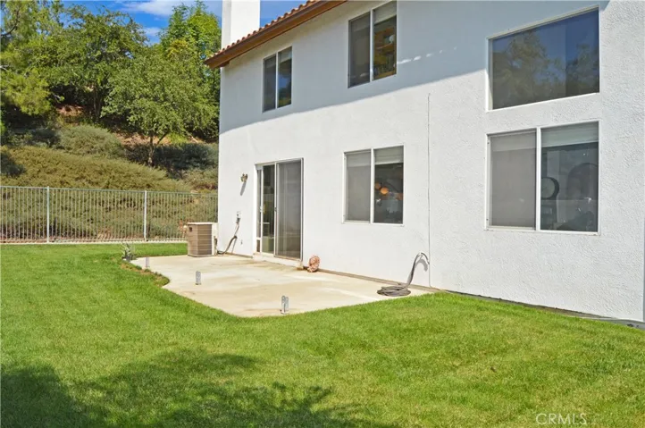 Nice-Sized Backyard with Concrete Patio, Lush Lawn, Vinyl Fencing by Neighbors & Wrought Iron Fencing to Enjoy Green Space Views to North