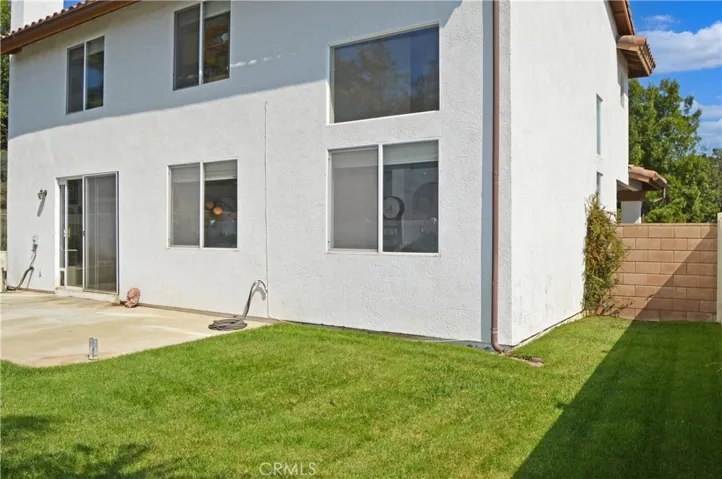 Nice-Sized Backyard with Concrete Patio, Lush Lawn, Vinyl Fencing by Neighbors & Wrought Iron Fencing to Enjoy Green Space Views to North