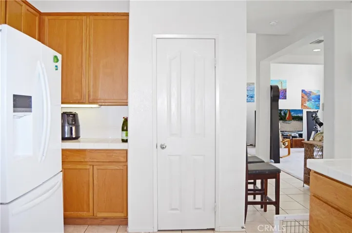 Light and Bright Kitchen with An Added Breakfast Bar with a Granite Insert for Dough-Making, Tile Floors, & a Pantry