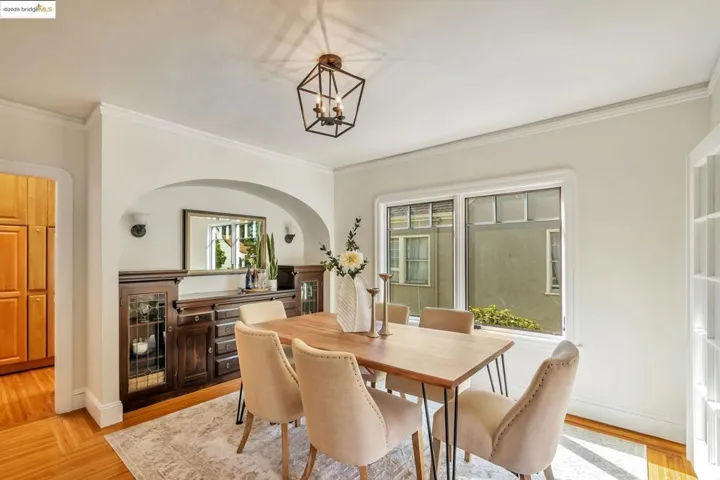 Dining room featuring ornamental molding, light wood-type flooring, and a chandelier