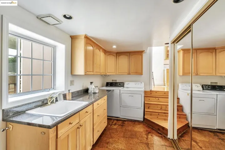 Laundry room with separate washer and dryer, cabinet space, and recessed lighting