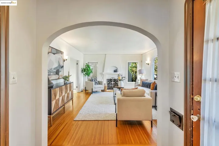 Living room with arched walkways and light wood-style flooring