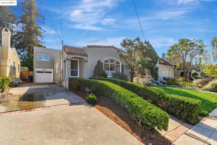 Mediterranean / spanish home with concrete driveway, stucco siding, a tile roof, and a garage