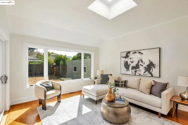 Living room featuring a skylight, wood finished floors, and lofted ceiling