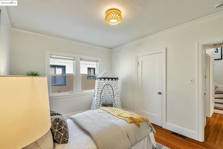 Bedroom featuring crown molding and wood finished floors