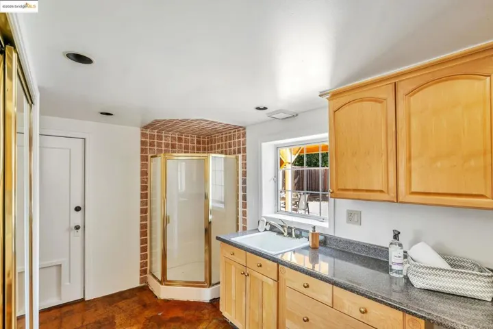 Kitchen featuring light brown cabinets and dark stone countertops