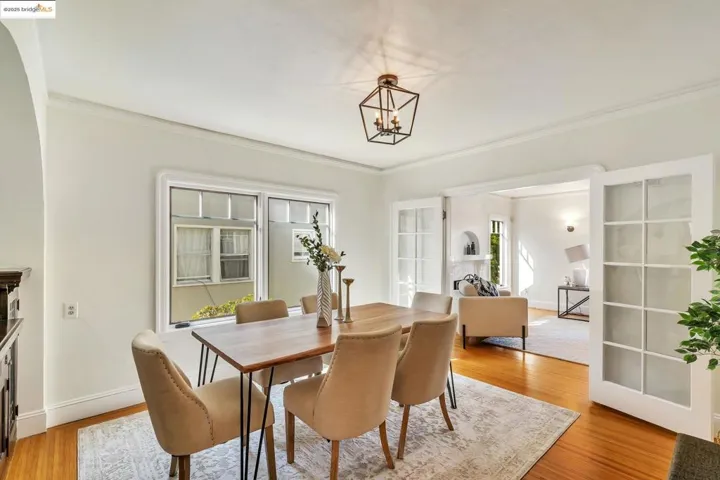 Dining area featuring light wood finished floors, crown molding, and french doors