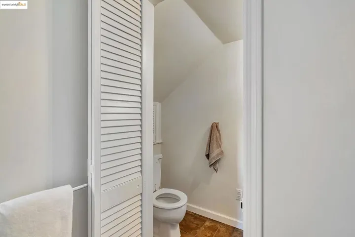 Bathroom with toilet and lofted ceiling
