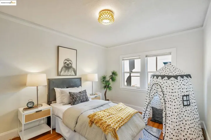 Bedroom with ornamental molding and wood finished floors
