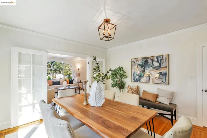 Dining space featuring light wood-type flooring, crown molding, and a chandelier