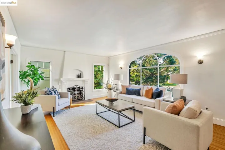 Living room with a fireplace, light wood finished floors, plenty of natural light, and crown molding