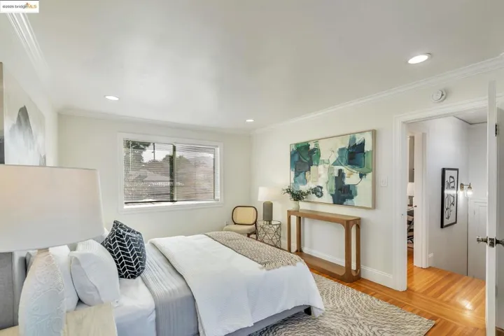 Bedroom with light wood-style flooring, crown molding, and recessed lighting