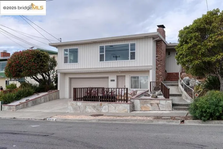 Traditional home featuring concrete driveway, a garage, and a chimney