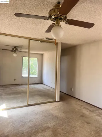 Unfurnished bedroom featuring a textured ceiling, carpet flooring, and a closet