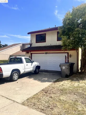 Traditional-style house featuring driveway, a garage, and stucco siding