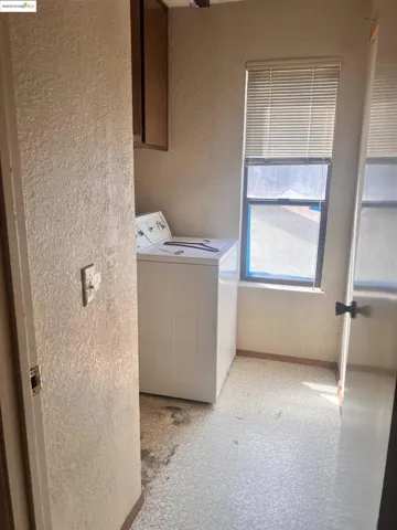 Washroom with a textured wall and light flooring