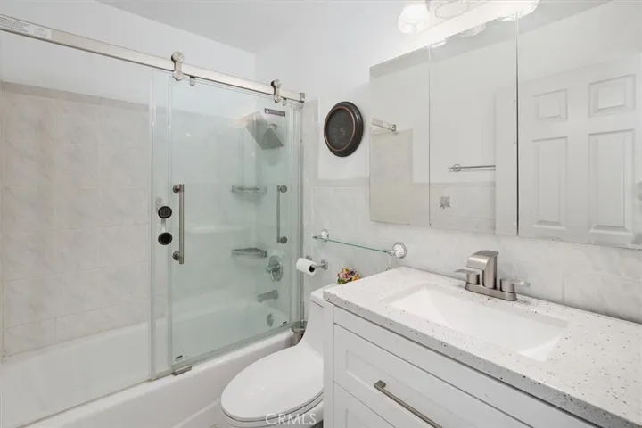 Hallway bathroom has upgraded vanity and fixture.  Tub has new glass door enclosure