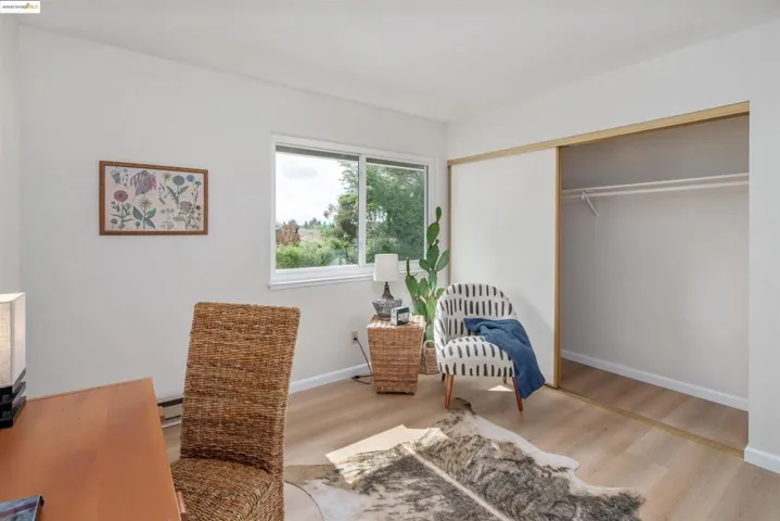 Sitting room with wood finished floors and a baseboard radiator