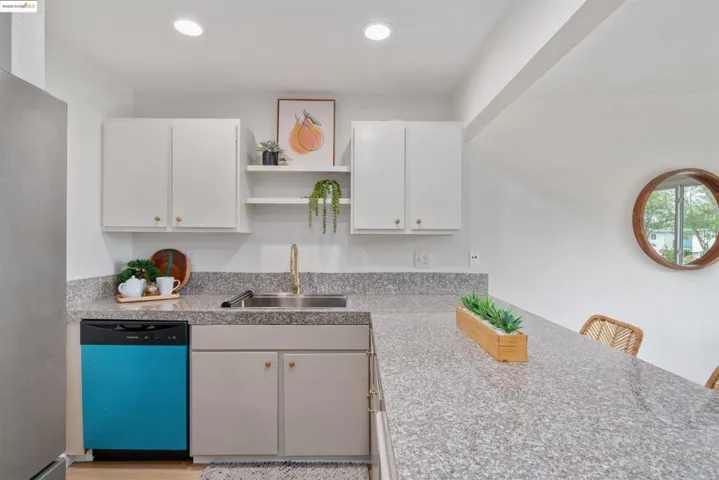 Kitchen featuring dishwashing machine, light countertops, freestanding refrigerator, open shelves, and recessed lighting