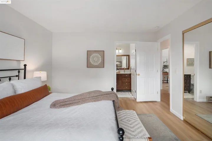 Bedroom with light wood finished floors and ensuite bathroom