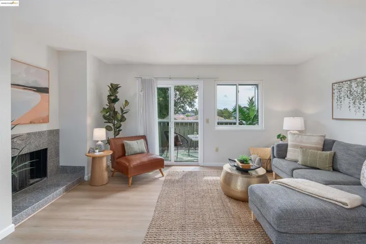 Living area with light wood finished floors and a high end fireplace