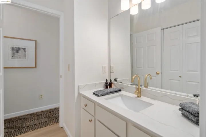 Bathroom with vanity, light wood-type flooring, and a closet