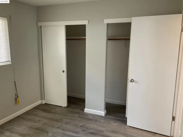 Unfurnished bedroom with multiple closets and light wood-style floors