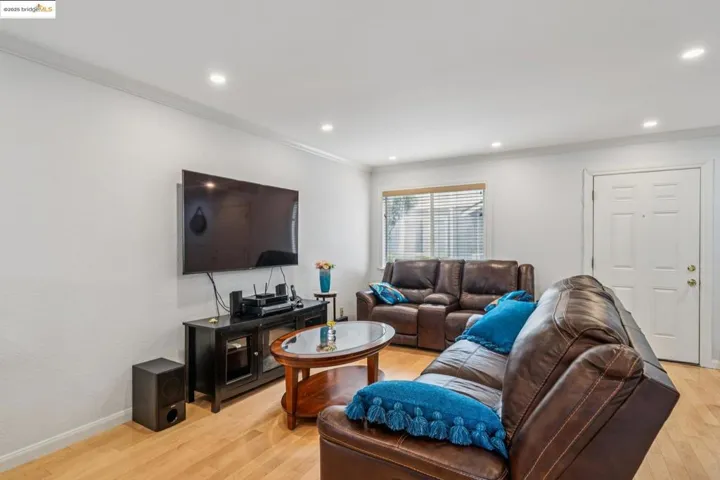 Living area featuring ornamental molding, light wood-style flooring, and recessed lighting