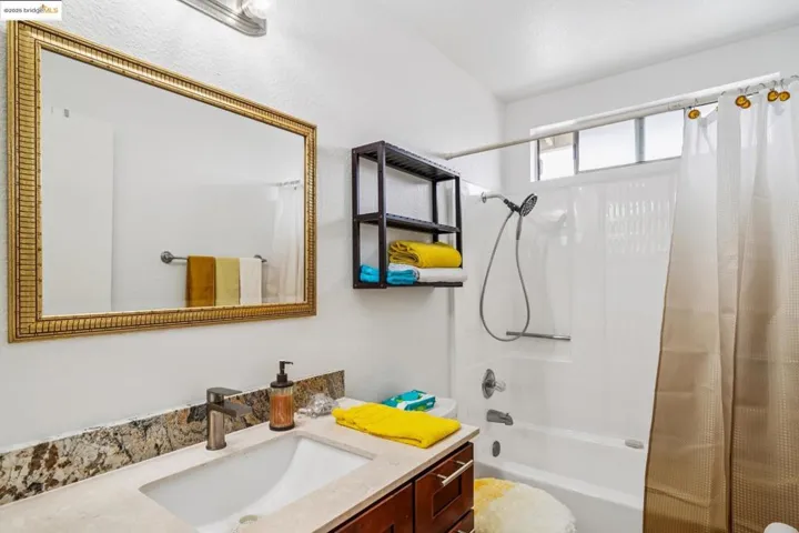 Full bathroom with shower / bath combo and vanity