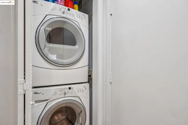 Washroom featuring stacked washer and clothes dryer