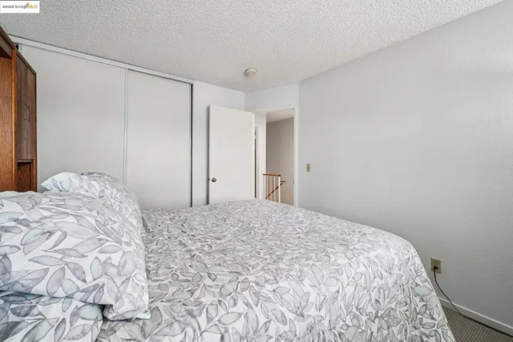 Bedroom with a textured ceiling, a closet, and carpet floors