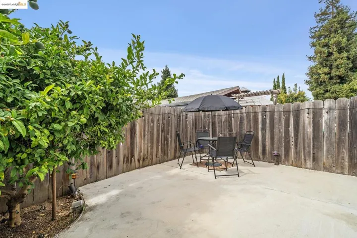 Fenced backyard with outdoor dining area and a patio